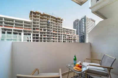 a table and chairs on a balcony with a building at Frank Porter - G24 Tower in Dubai