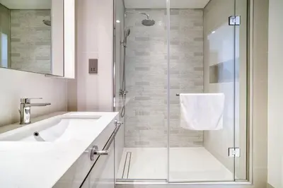 a white bathroom with a shower and a sink at New 2 bedroom full sea view in Dubai