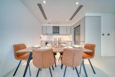 a dining room with a wooden table and chairs at New 2 bedroom full sea view in Dubai