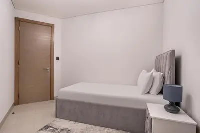 a white bedroom with a bed and a door at STAY BY LATINEM Luxury 2BR Holiday Home W205 near Burj Khalifa in Dubai