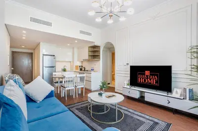 a living room with a blue couch and a kitchen at Clse Elegance Redefined Luxury 1 Bedroom Apartment with Premium Facilities in Dubai