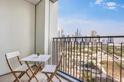 a balcony with a table and chairs and a view of the city at Clse Elegance Redefined Luxury 1 Bedroom Apartment with Premium Facilities in Dubai