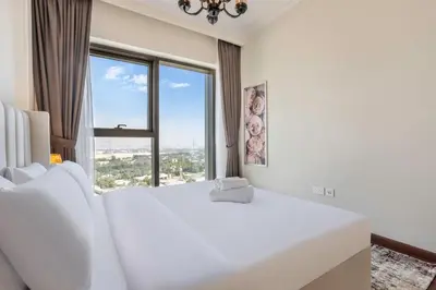 a white bedroom with a large window at Clse Elegance Redefined Luxury 1 Bedroom Apartment with Premium Facilities in Dubai
