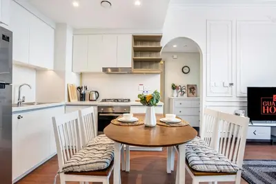 a kitchen with a wooden table and chairs in a kitchen at Clse Elegance Redefined Luxury 1 Bedroom Apartment with Premium Facilities in Dubai