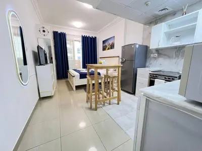 a kitchen with a small table and a refrigerator at Brand New and Stylish Interior in Dubai