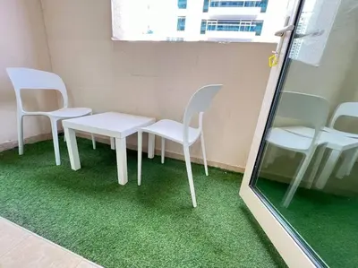 a room with two white chairs and a table at Brand New and Stylish Interior in Dubai