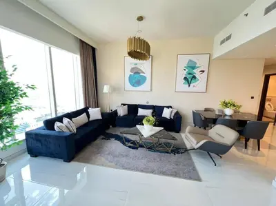 a living room with a blue couch and a table at Luxury 2BR Avani Palm View Apt in Dubai