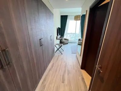 a room with a hallway with a door and a living room at Luxury 2BR Avani Palm View Apt in Dubai