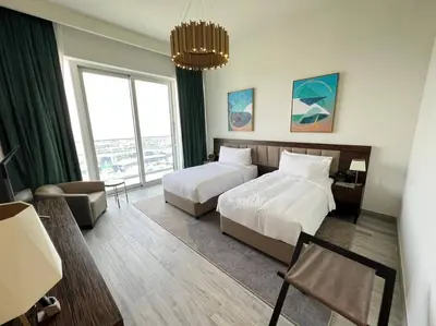 a hotel room with two beds and a large window at Luxury 2BR Avani Palm View Apt in Dubai