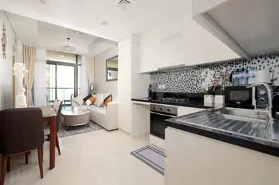 a kitchen and living room with a sink and a table at Chic Aykon City 2-Bedroom Retreat - Business Bay in Dubai