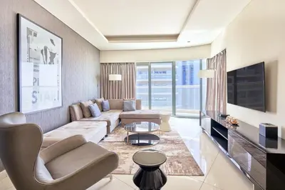 a living room with a couch and a tv at Spacious 3BHK in Paramount Tower B with Stunning Views-6204 in Dubai
