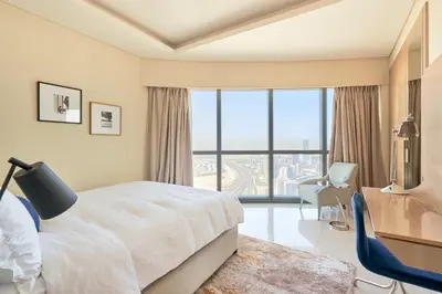 a bedroom with a bed and a desk and a window at Spacious 3BHK in Paramount Tower B with Stunning Views-6204 in Dubai
