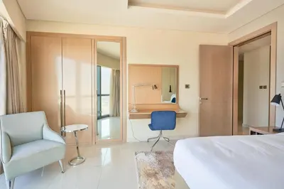 a bedroom with a bed and a chair and a desk at Spacious 3BHK in Paramount Tower B with Stunning Views-6204 in Dubai