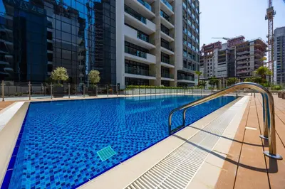 a swimming pool with a stairway leading to a building at Urban Oasis - Cosy Studio Retreat in Dubai