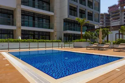 a swimming pool in front of a building at Urban Oasis - Cosy Studio Retreat in Dubai