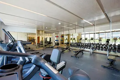 a gym with a lot of treadmills and machines at Urban Oasis - Cosy Studio Retreat in Dubai
