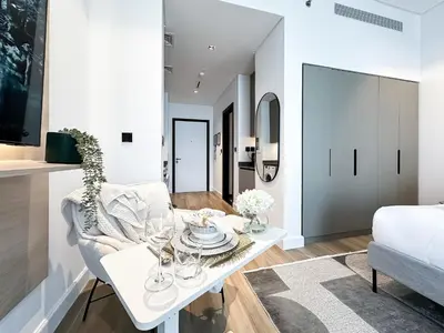 a white dining room with a white table and chairs at Modern Marvel Studio in Business Bay in Dubai