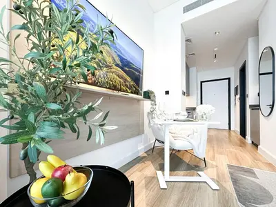 a dining room with a painting on the wall and a bowl of fruit at Modern Marvel Studio in Business Bay in Dubai