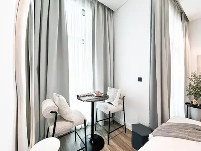 a bedroom with a bed and a table and chairs at Modern Marvel Studio in Business Bay in Dubai