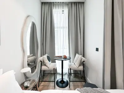 a bedroom with a table and chairs and a mirror at Modern Marvel Studio in Business Bay in Dubai