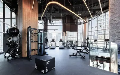 a gym with cardio equipment in a large room with windows at Modern Marvel Studio in Business Bay in Dubai