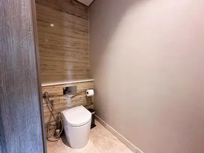 a bathroom with a toilet and a wooden wall at Chic 1-Bedroom in Sterling Tower, Downtown Stay - 17AB05 in Dubai