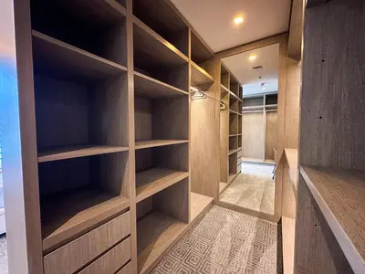 a walk in closet with wooden shelves at Chic 1-Bedroom in Sterling Tower, Downtown Stay - 17AB05 in Dubai