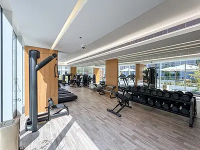 a gym with treadmills and equipment in a building at Cozy & Bright Home in the Heart of JVC in Dubai