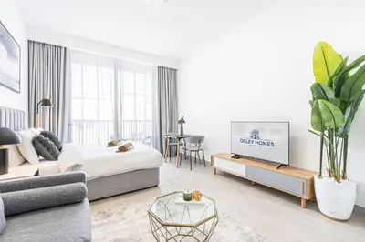 a living room with a bed and a tv in it at Cozy & Bright Home in the Heart of JVC in Dubai
