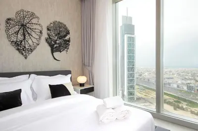 a bedroom with a bed and a large window at Downtown Luxury - Stunning 2BHK with Sea view in Forte towers, Downtown in Dubai