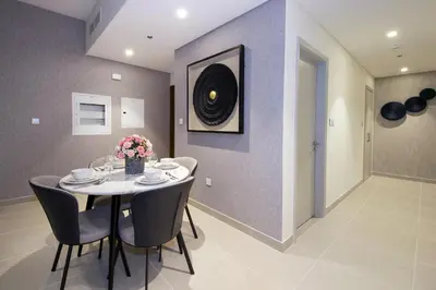 a dining room with a table and chairs with flowers at Downtown Luxury - Stunning 2BHK with Sea view in Forte towers, Downtown in Dubai