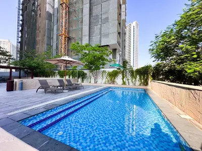 a swimming pool with two chairs and an umbrella at Luxurious 2BR in Vezul Residence, Business Bay - 13AB01 in Dubai