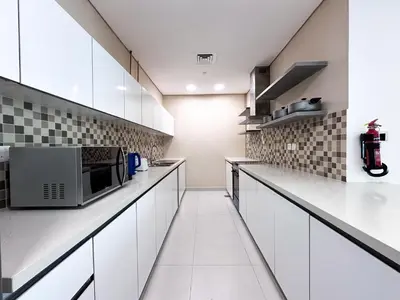 a kitchen with white cabinets and a microwave at Luxurious 2BR in Vezul Residence, Business Bay - 13AB01 in Dubai