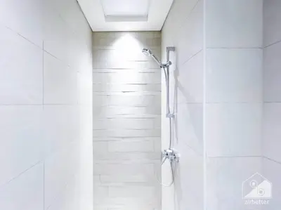 a shower in a bathroom with white tiles at Amazing Studio with Balcony & View Riviera Meydan in Dubai