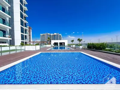 a large blue swimming pool in a building at Amazing Studio with Balcony & View Riviera Meydan in Dubai