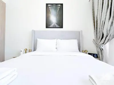a bedroom with a white bed with a picture above it at Amazing Studio with Balcony & View Riviera Meydan in Dubai