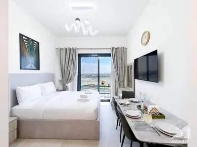 a hotel room with a bed and a dining table at Amazing Studio with Balcony & View Riviera Meydan in Dubai