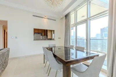 a dining room with a glass table and chairs at Spacious 3BDR Apartment in Marina with Office in Dubai