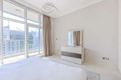 a white bedroom with large windows and a bed at Spacious 3BDR Apartment in Marina with Office in Dubai