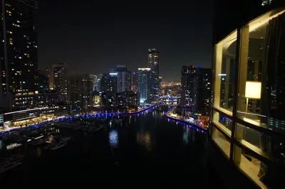 a view of a city at night with a river at 2 Bedroom Apartment full Marina View in Dubai