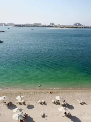 a beach with chairs and umbrellas and the ocean at BrandNew, OceanView, PrivateBeach, 1bed in Dubai