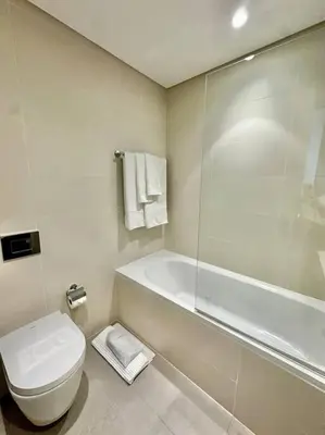 a white bathroom with a toilet and a shower at BrandNew, OceanView, PrivateBeach, 1bed in Dubai