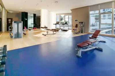 a gym with several chairs and a blue floor at Modern Home in Business Bay with Panoramic View in Dubai