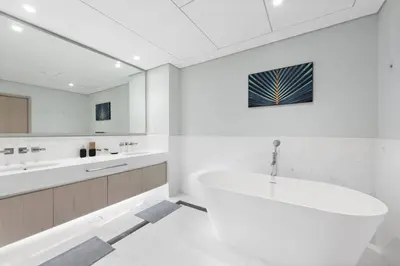 a white bathroom with a tub and a sink at Stunning 1-BR Apartment In Heart Of The Palm in Dubai