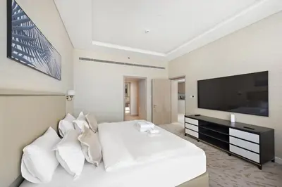 a bedroom with a white bed and a flat screen tv at Stunning 1-BR Apartment In Heart Of The Palm in Dubai