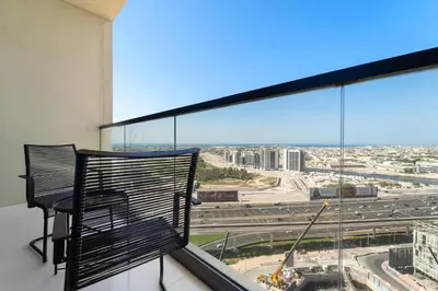 a balcony with two chairs and a view of a city at Silkhaus New Modern Studio In New Tower at Business Bay in Dubai