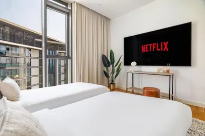 two beds in a hotel room with a tv at GuestReady - Magnificent stay in Bluewaters Island in Dubai