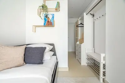 a bedroom with white walls and a bed with pillows at GuestReady - Magnificent stay in Bluewaters Island in Dubai