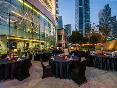 a restaurant with tables and chairs in front of a building at Cosmos Living Sleek and Stylish GCV2 in Dubai