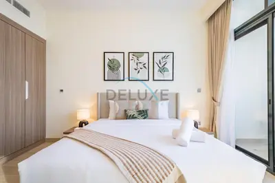 a bedroom with a large white bed and two lamps at Calming Studio Apartment at Azizi Riviera 4, Al Merkadh by Deluxe Holiday Homes in Dubai